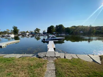 a boat is docked in the water on a lake at Charming Home on Esopus Creek in Saugerties