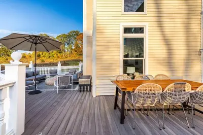a deck with a wooden table and chairs and an umbrella at Rhinebrook Estate 8 Bed 11 Bath Sleeps 20 in Hyde Park