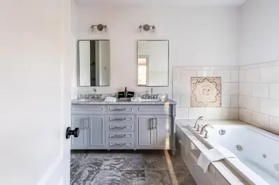 a white bathroom with a tub and a sink at Rhinebrook Estate 8 Bed 11 Bath Sleeps 20 in Hyde Park