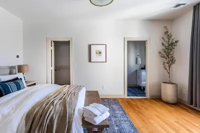 a white bedroom with a bed and a potted plant at Rhinebrook Estate 8 Bed 11 Bath Sleeps 20 in Hyde Park