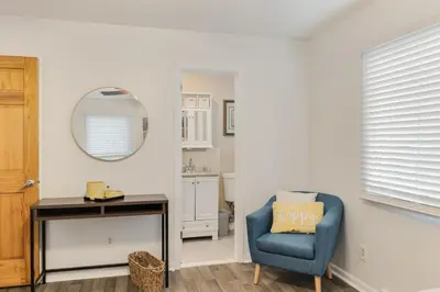 a living room with a blue chair and a mirror at Mansion in the Hills with Pool in Monroe