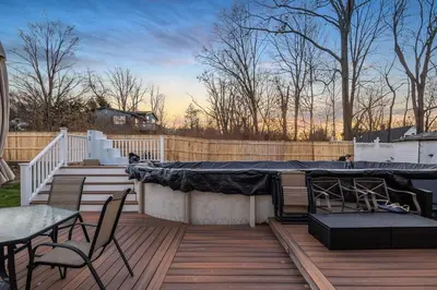 a wooden deck with chairs and a hot tub on it at Mansion in the Hills with Pool in Monroe