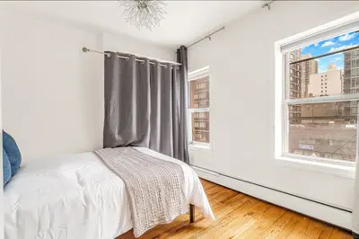 a bedroom with a bed and a window at Spacious 3BR Apartment in Kips Bay - Central Manhattan Location! in New York