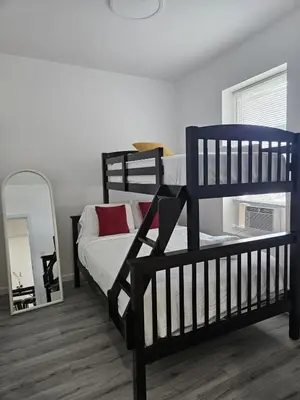 a bedroom with two bunk beds and a mirror at 20 minutes to Central Park Manhattan New York City 16 mins Metlife stadium in West New York