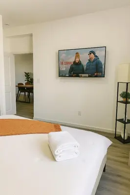 a flat screen tv hanging on a wall in a bedroom at 20 minutes to Central Park Manhattan New York City 16 mins Metlife stadium in West New York