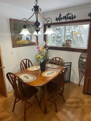 a dining room table with chairs and a vase with flowers at Adirondack Trailside Cabin in Caroga Lake