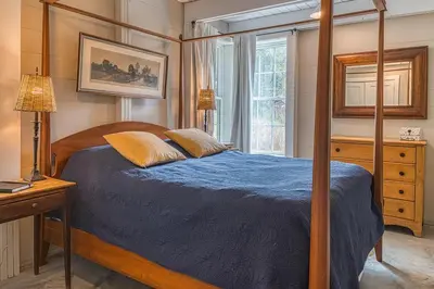 a bedroom with a bed with a blue comforter at Brand New Barn House in Stockbridge