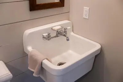 a white sink in a bathroom with a towel at Brand New Barn House in Stockbridge