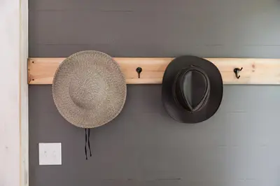 a hat and a mirror on a shelf on a wall at Brand New Barn House in Stockbridge