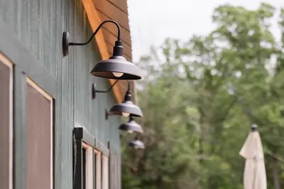 a couple of lights hanging on the side of a building at Brand New Barn House in Stockbridge