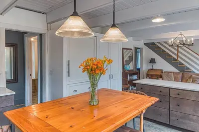 a vase of flowers on a wooden table in a kitchen at Brand New Barn House in Stockbridge
