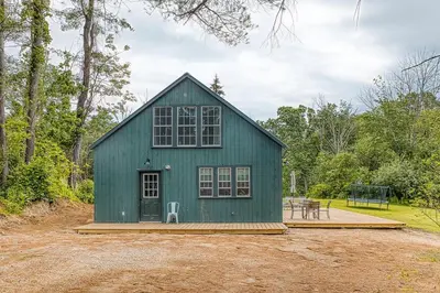 a green barn with a picnic table in front of it at Brand New Barn House in Stockbridge
