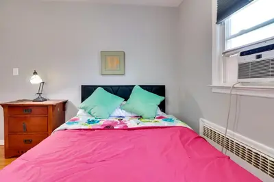 a pink bed in a room with a window at The Vault Your Fun Secured in Hillside