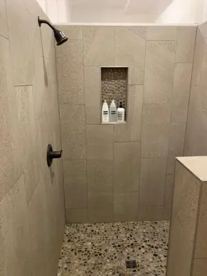 a bathroom with a shower with two bottles on a shelf at Riverbend Berkshire East Basecamp in Charlemont