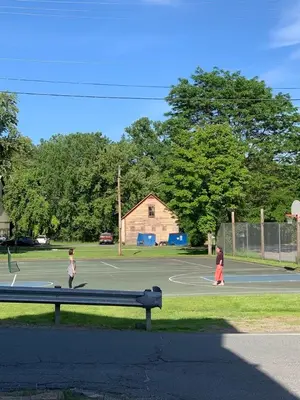 two children are playing on a basketball court at Riverbend Berkshire East Basecamp in Charlemont