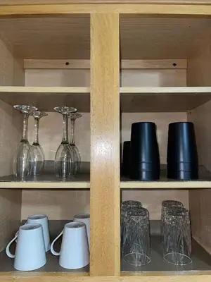 a shelf with glasses and other glass items on it at Cozy 2 Bedrooms 1and half Bathrooms Near Prudential with Parking Entire Apartment in Newark