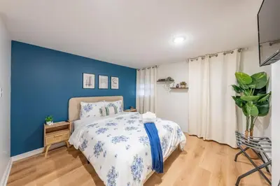 a bedroom with a blue accent wall and a bed at 5BR 3BTH House, Steps to Bars, Dining, NYC Access with GameRm, Backyard with BBQ and Parking in Jersey City