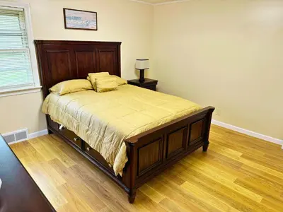 a bedroom with a large bed with a wooden headboard at Cozy Riverside View House in Montague