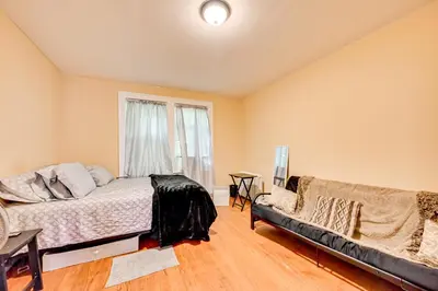a bedroom with a bed and a couch and a window at Convenient Hartford Condo Less Than 2 Mi to Dtwn! in Hartford