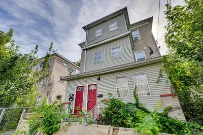 a house with a red door on a street at Convenient Hartford Condo Less Than 2 Mi to Dtwn! in Hartford