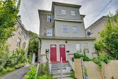 an old house with a red door on a street at Convenient Hartford Condo Less Than 2 Mi to Dtwn! in Hartford