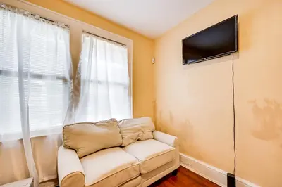 a living room with a couch and a flat screen tv at Convenient Hartford Condo Less Than 2 Mi to Dtwn! in Hartford