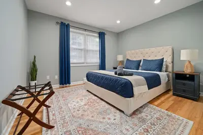 a bedroom with a king sized bed and blue curtains at 3BR Apt Near Train Balcony Yonkers in Yonkers