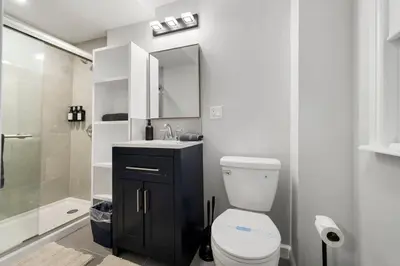 a bathroom with a toilet and a sink and a shower at Spacious 3BR Apt Near MetroNorth in Yonkers