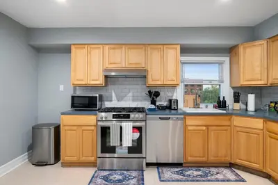 a kitchen with wooden cabinets and a stove at Spacious 3BR Apt Near MetroNorth in Yonkers