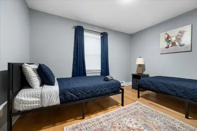 a bedroom with two beds and a window at 6 bdr Yonkers Home 2 Apts Balcony & Parking in Yonkers