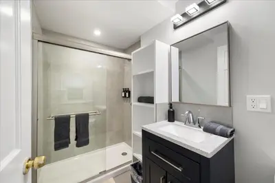 a bathroom with a sink and a shower with a mirror at 6 bdr Yonkers Home 2 Apts Balcony & Parking in Yonkers