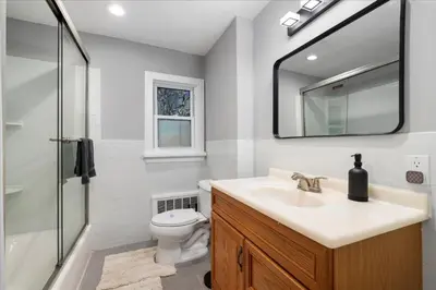 a bathroom with a sink and a toilet and a mirror at 6 bdr Yonkers Home 2 Apts Balcony & Parking in Yonkers