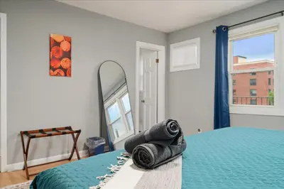 a bedroom with a bed with a mirror and towels at 6 bdr Yonkers Home 2 Apts Balcony & Parking in Yonkers