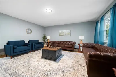 a living room with leather furniture and blue walls at 6 bdr Yonkers Home 2 Apts Balcony & Parking in Yonkers
