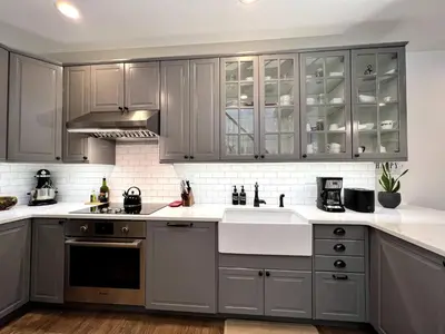 a kitchen with gray cabinets and white counter tops at Luxury duplex - 10 min to NYC/Times Square in Hoboken