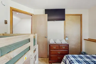 a bedroom with a bunk bed and a dresser and a mirror at Haystack 32 in Wilmington