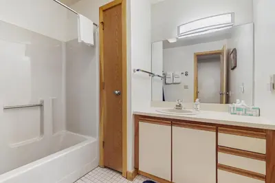 a bathroom with a sink and a tub and a mirror at Haystack 32 in Wilmington