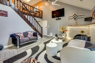 a living room with a couch and a staircase at Poconos Family Home with Game Room and Community Perks in East Stroudsburg