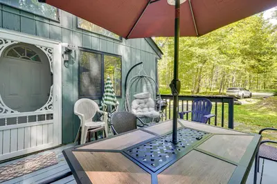 a patio with a table and chairs and an umbrella at Poconos Family Home with Game Room and Community Perks in East Stroudsburg