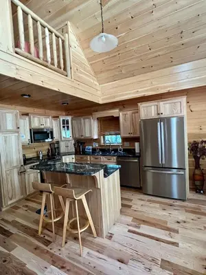 a kitchen with wooden ceilings and a stainless steel refrigerator at Luxury Cabin with Outdoor HotTub-NEW Construction in Lake Ariel