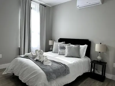 a white bedroom with a bed with a towel on it at Spacious Modern 1 Bedroom RARE Apt w GYM in Albany