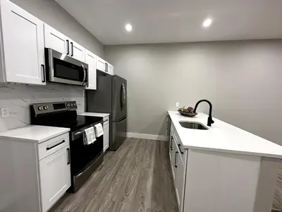 a kitchen with a sink and a microwave at Spacious Modern 1 Bedroom RARE Apt w GYM in Albany