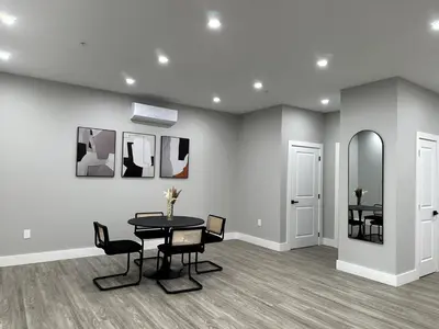 a dining room with a table and chairs and a mirror at Spacious Modern 1 Bedroom RARE Apt w GYM in Albany