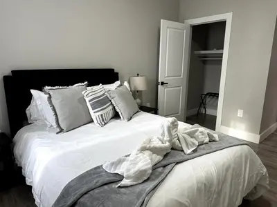 a bedroom with a bed with white sheets and pillows at Spacious Modern 1 Bedroom RARE Apt w GYM in Albany