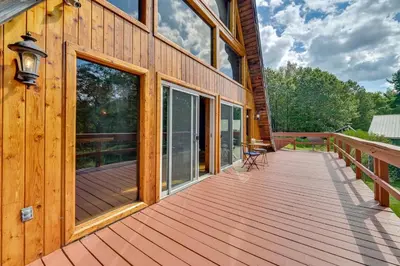 a large wooden deck on the side of a house at A-Frame Retreat Next to Grafton Lakes St Park