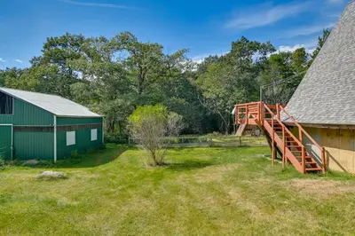 a yard with a green building and a playground at A-Frame Retreat Next to Grafton Lakes St Park