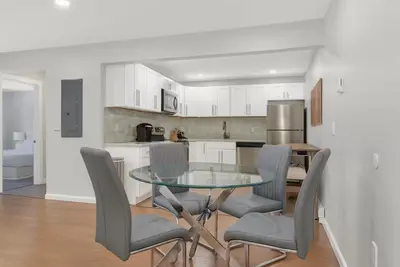 a kitchen with a glass table and gray chairs at Westville Nest parking NearYale Newly Renovated in New Haven