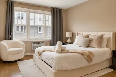 a bedroom with a bed and a chair and a window at Westville Nest parking NearYale Newly Renovated in New Haven