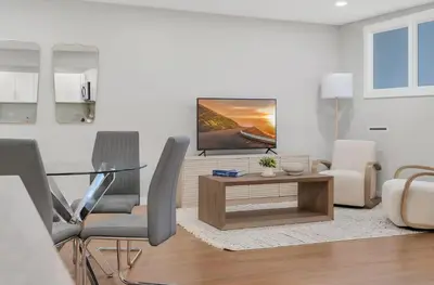 a living room with a tv and a table and chairs at Westville Nest parking NearYale Newly Renovated in New Haven