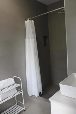 a shower with a white shower curtain in a bathroom at CHIC, Renovated Brownstone in PRIME DT Albany in Albany